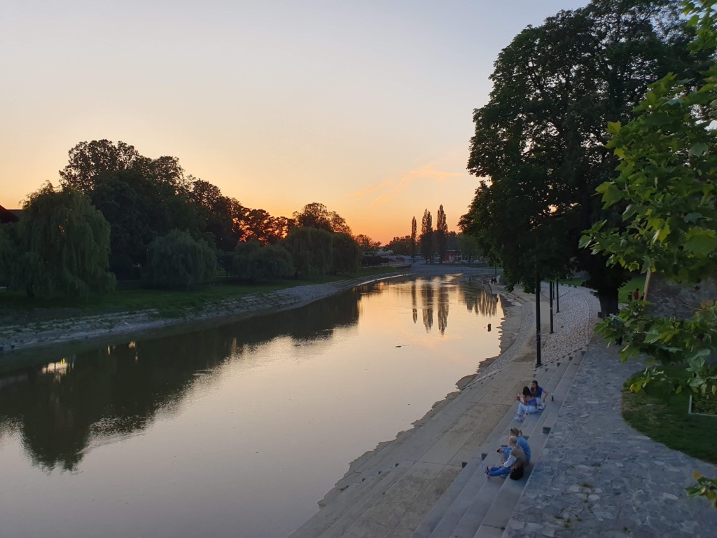 People on river banks sunset