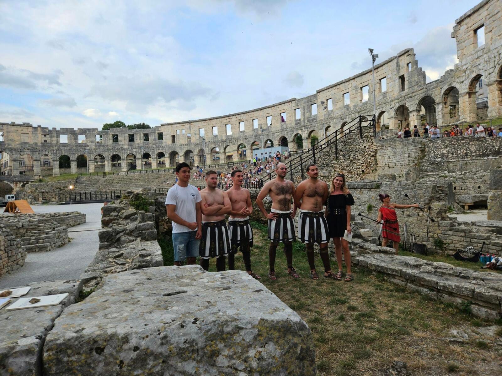 Gladiator performers posing with visitors inside Pula Arena